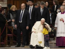 el papa francisco besa a una niña cuando llega para presidir las primeras vísperas
