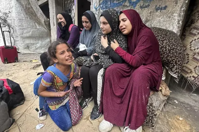 Supervivientes palestinos reaccionan ante los escombros del edificio de su familia